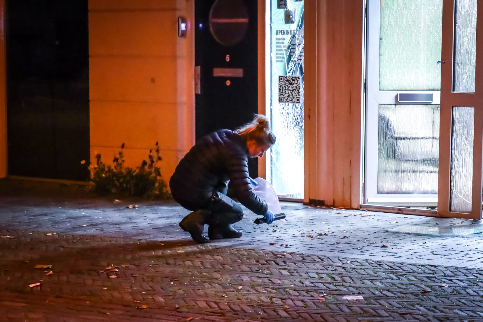 Een explosievenverkenner van het Team Explosieven Verkenning (TEV) onderzoekt het niet-ontplofte explosief voor de kapperszaak aan de Westhavenkade.