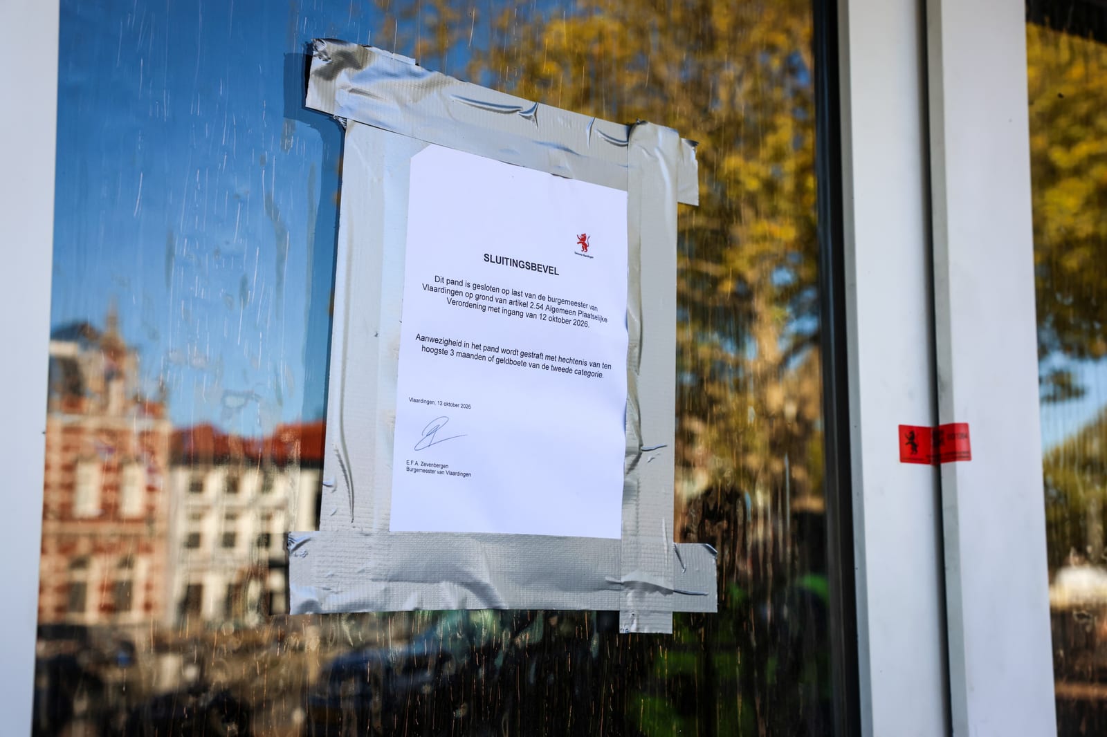 Het officiële sluitingsbevel hangt op de deur van de kapperszaak aan de Westhavenkade.