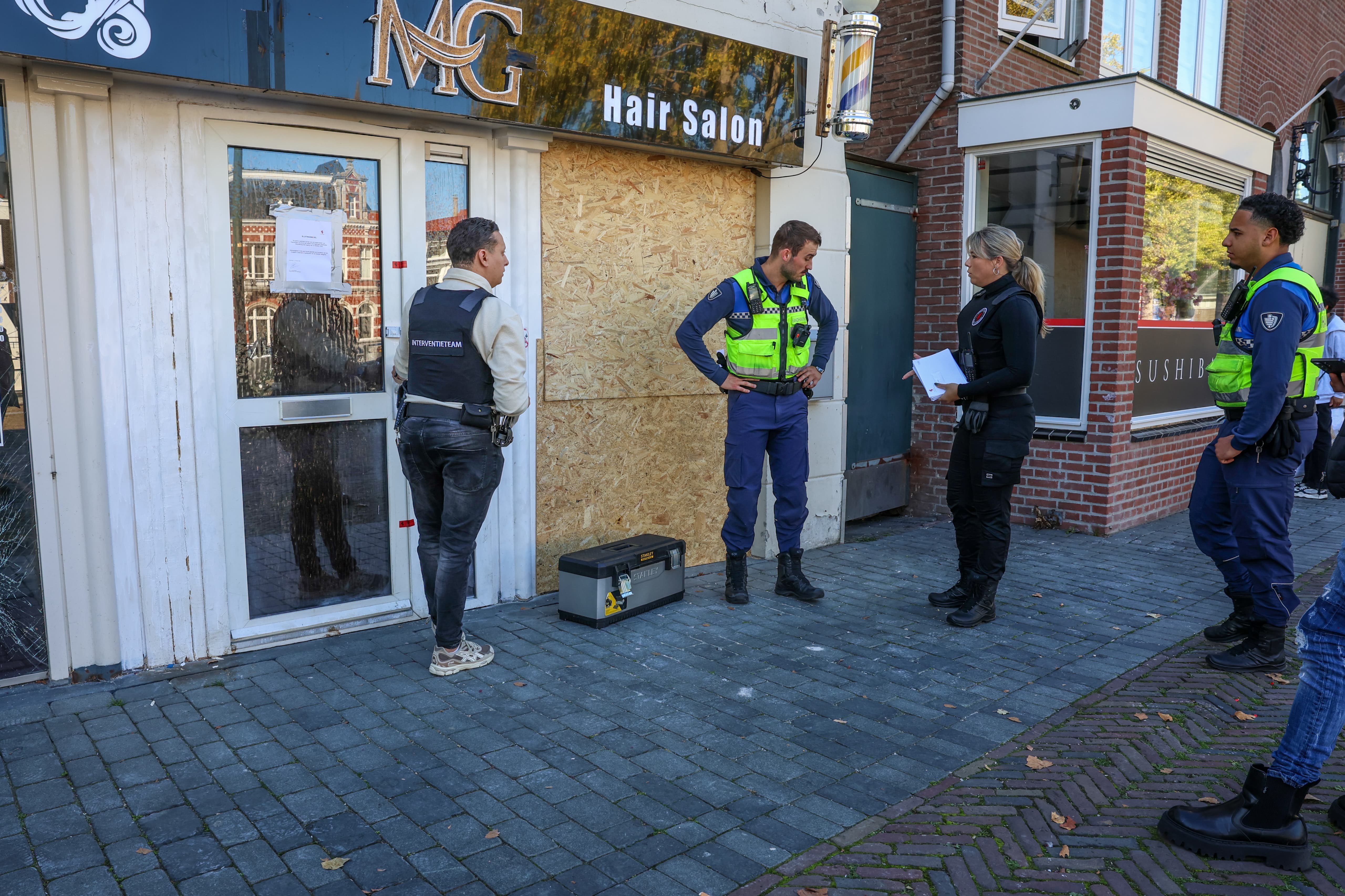 Handhavers en het interventieteam van de gemeente zijn aanwezig bij de gesloten kapperszaak.